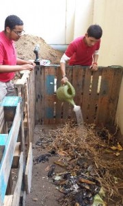 Estudiantes trabajando una compostera para desarrollar un huerto urbano.